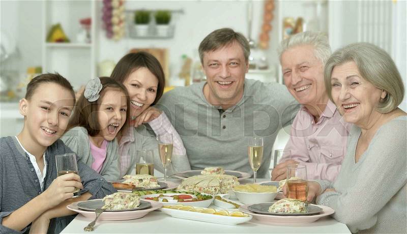 Portrait of happy family at the table with tasty food, stock photo