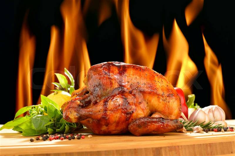 Roasted chicken and various vegetables on a chopping wood, stock photo