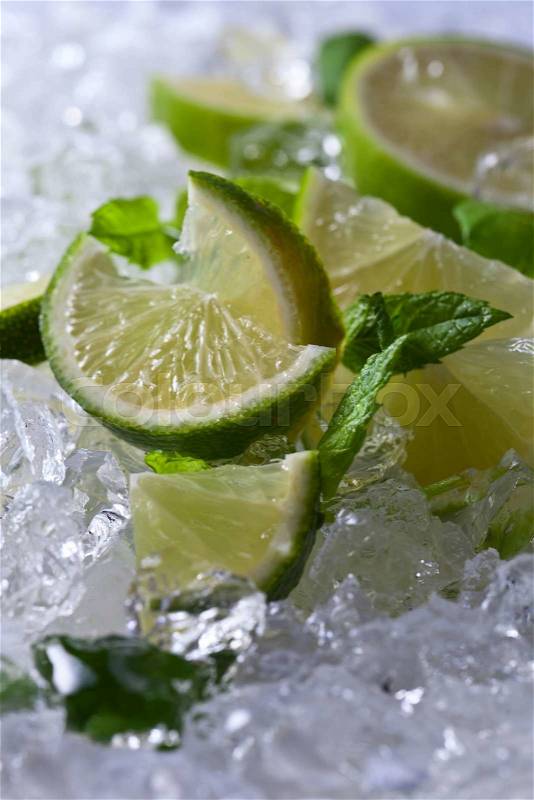Lime pieces and leaves of peppermint with ice\, stock photo