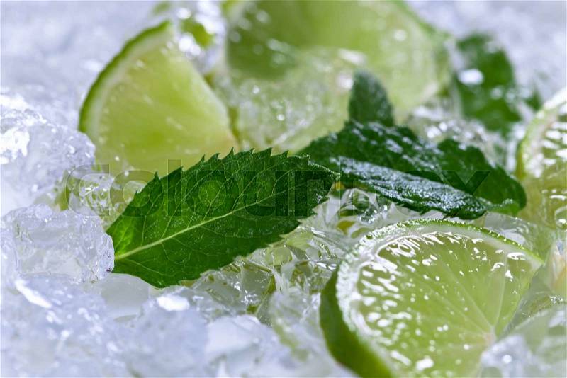 Lime slices with ice and peppermint leaves , stock photo