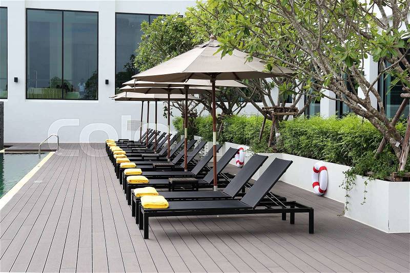 Row of the Swimming pool chair and umbrella, stock photo