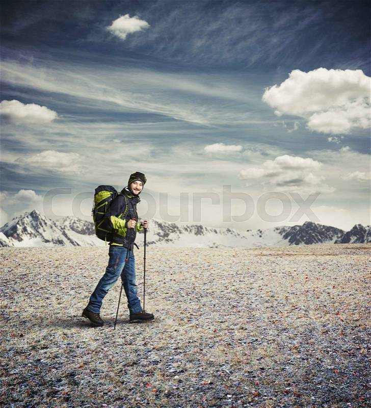 Man wear winter clothes with hiking poles and goggles in the mountains, stock photo