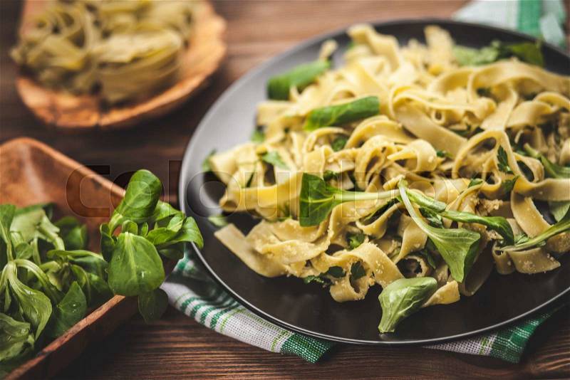 Cooked tagliatelle pasta with greens and grated parmesan cheese, stock photo
