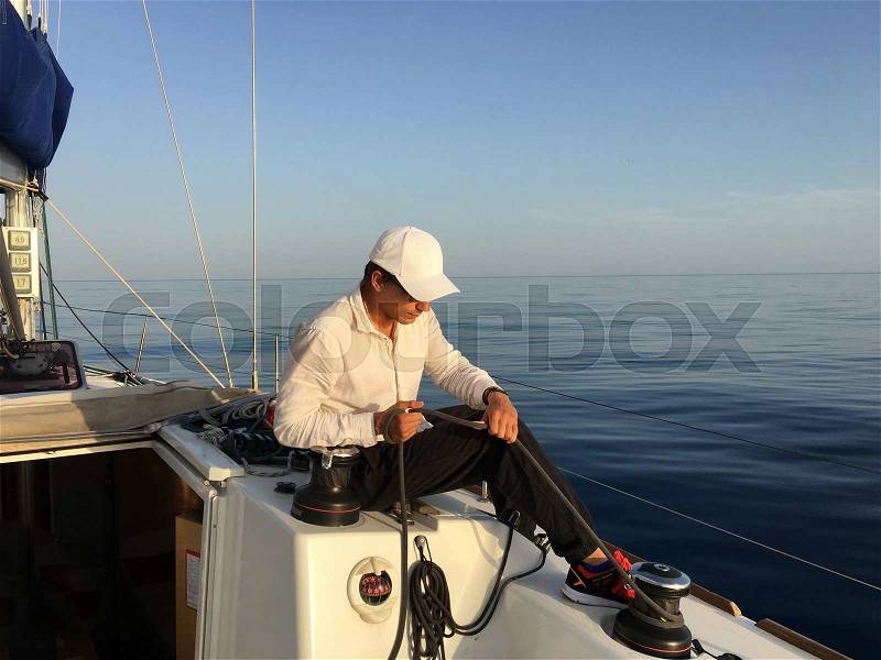 Young man sailing yacht yachtsman holding hands rope vacation sail holidays people travel, stock photo