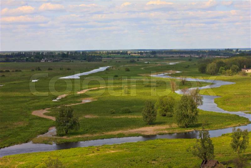 Flat landscape with two rivers, grass and trees on the horizon, stock photo