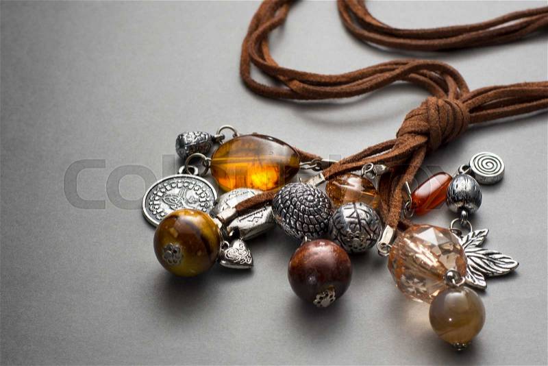 Close up of silver and glass beaded necklaces on brown leather string bunched together, stock photo
