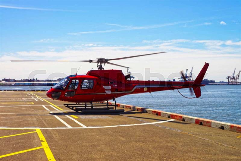 Red Helicopter on the helipad in Lower Manhattan in New York, USA, on East River. Pier 6, stock photo