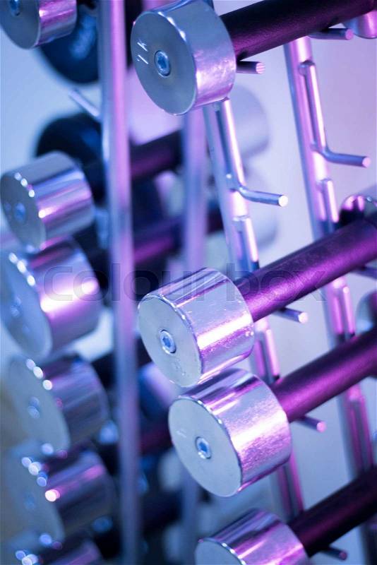 Dumbbell weights on dumbells rack in fitness gym for weight training, bodybuilding and sports strength training, stock photo