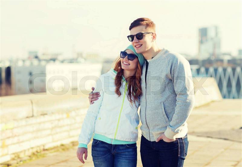 People, love and friendship concept - happy teenage couple walking in city, stock photo
