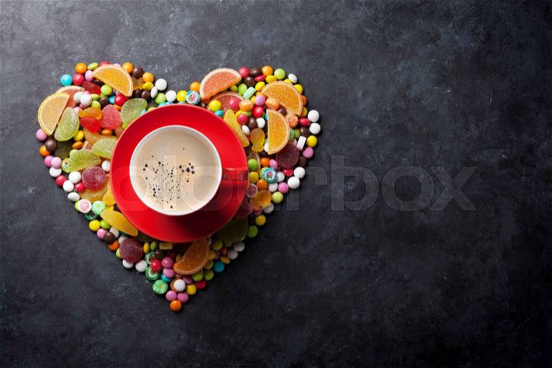 Colorful candies, jelly and marmalade heart and coffee cup on stone background. Top view with copy space, stock photo