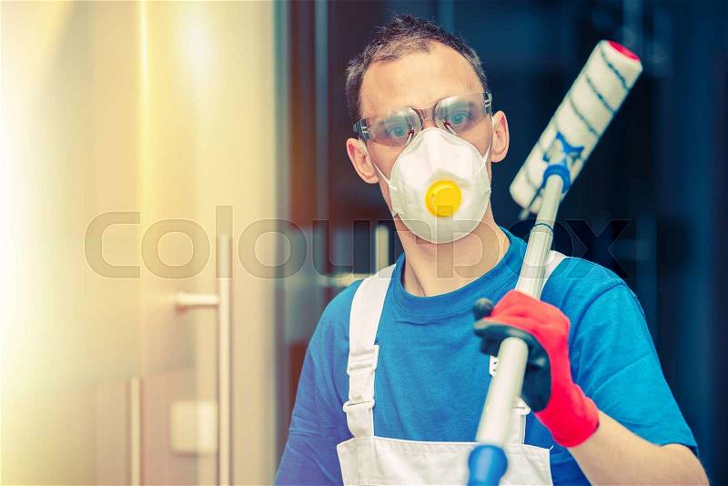 Pro House Painting. Professional House Painter with Painting Roller, Safety Mask and Glasses. Indoor Painting, stock photo