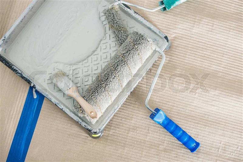 Roller Painting Equipment. White Paint in the Container with Roller and Paintbrush, stock photo