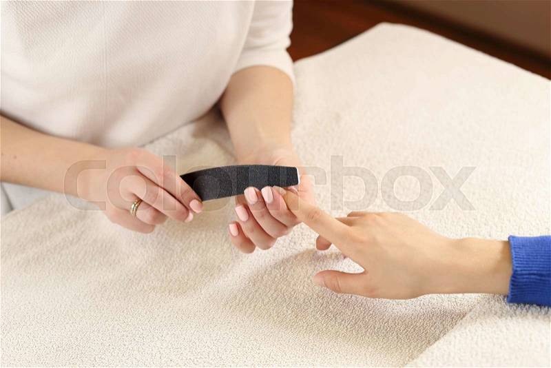 Filing nails process in spa salon, close up view, stock photo