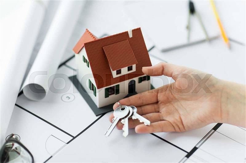 Architecture, building, construction, real estate and home concept - hand with house keys and blueprint, stock photo
