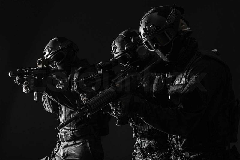Spec ops police officers SWAT in black uniform and face mask studio shot, stock photo