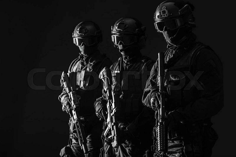 Spec ops police officers SWAT in black uniform and face mask studio shot, stock photo