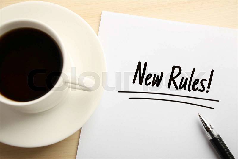 Text New Rules written on the white paper with coffee aside, stock photo