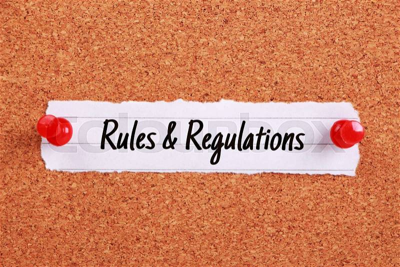 Text Rules And Regulations written on note paper pinned on the corkboard, stock photo