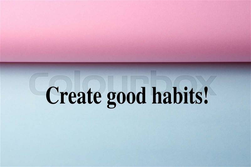 Black text Create Good Habits on the blue paper with pink paper aside, stock photo