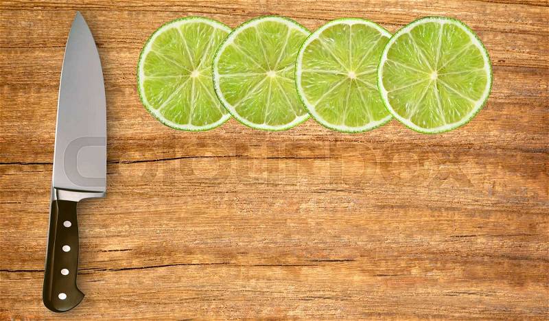 Lime slices and knife on cutting board isolated on white background, stock photo