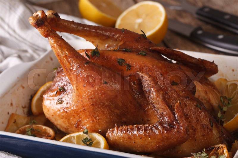 Whole chicken with lemon and thyme baked in a baking dish closeup. horizontal , stock photo