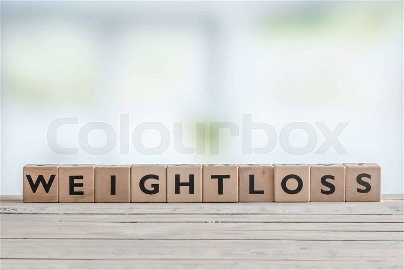 Weightloss sign with wooden cobes in a bright room, stock photo