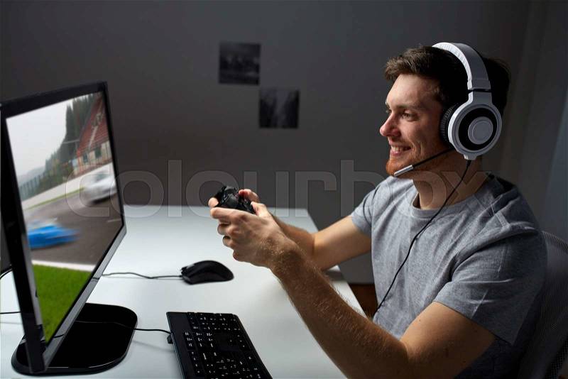 Technology, gaming, entertainment, let\'s play and people concept - happy young man in headset with controller gamepad playing computer game at home and streaming playthrough or walkthrough video, stock photo