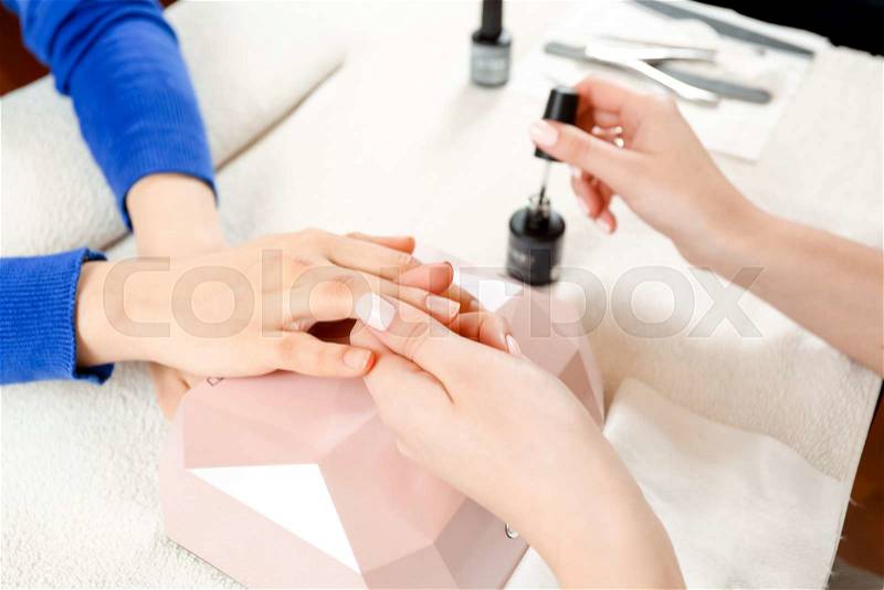 Top view and closeup of process of the nail coating in salon. The nails are ready for coating with nail polish, stock photo