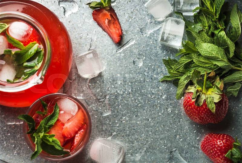 Homemade strawberry lemonade with mint and ice, served with fresh berries over metal tray surface, top view, copy space. Food frame and background , stock photo