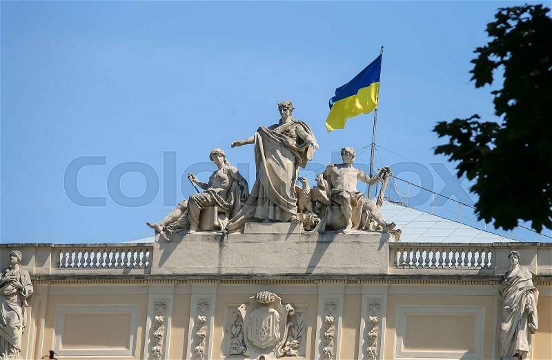 The upper part of Ivan Franko National University main building with National Flag of Ukraine. Allegorical sculpture composition Galicia, Vistula and Dniester. Lviv, Ukraine, stock photo