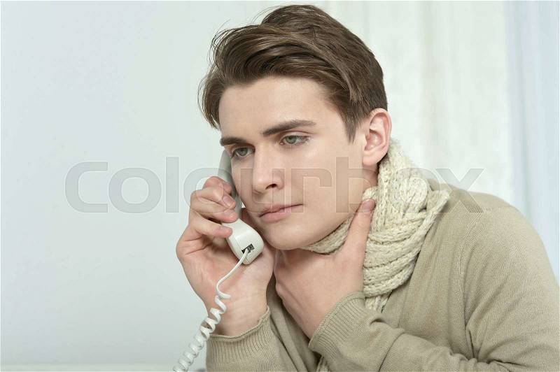 Portrait of sick man calling his doctor, stock photo