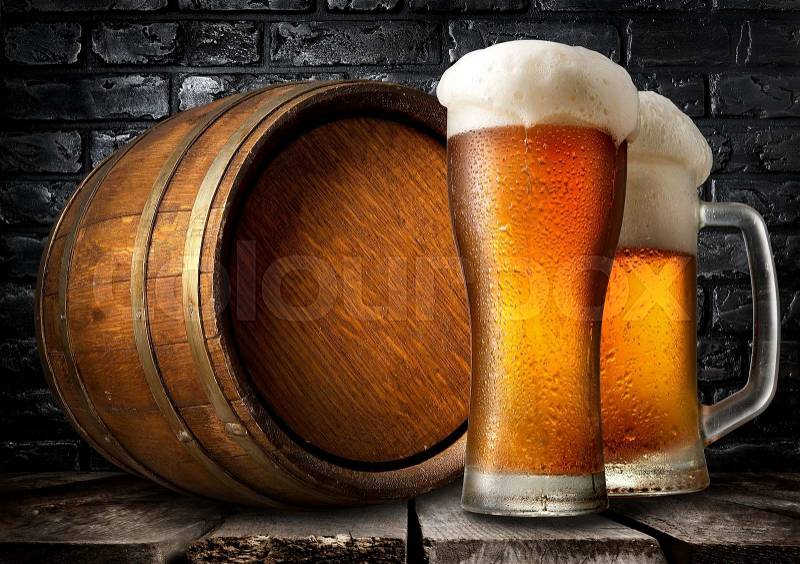 Beer and wooden keg near black brick wall, stock photo
