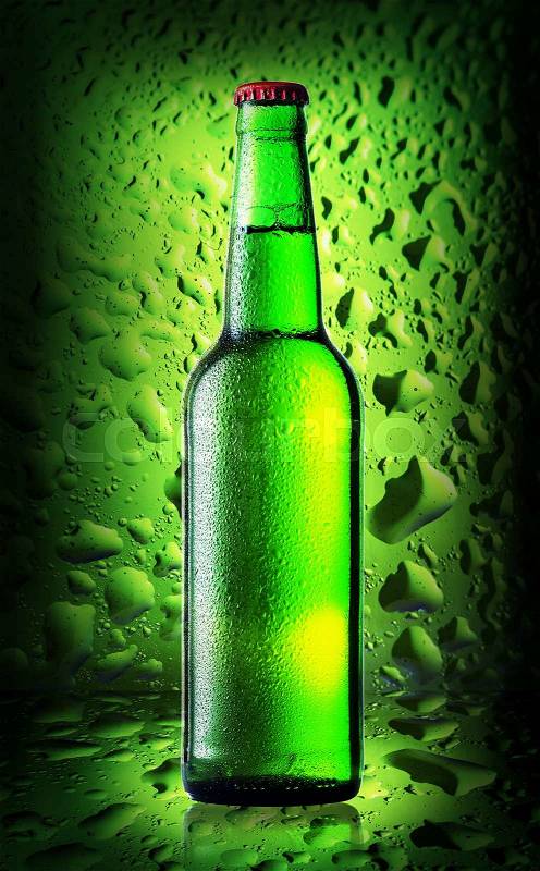 Green bottle cold beer on background of green glass with drops, stock photo