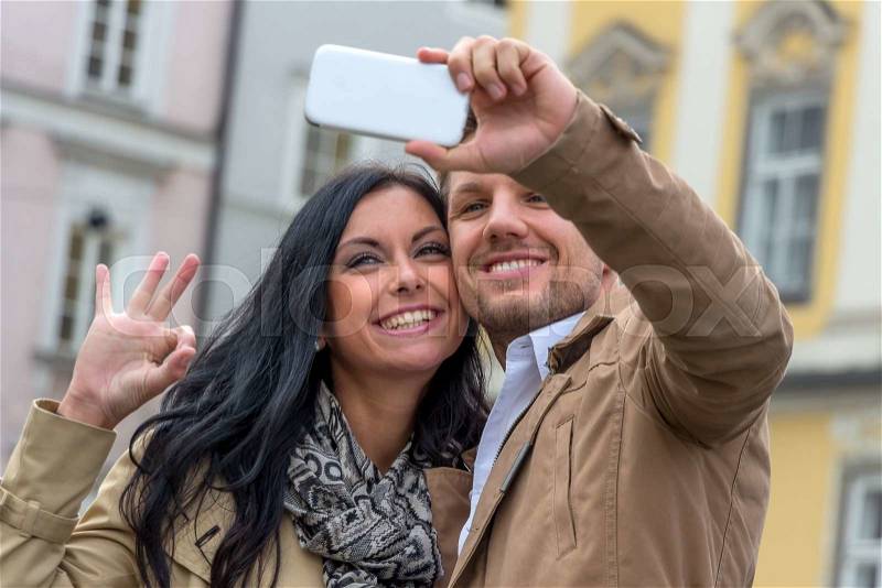 A young couple making a self-portrait with a cell phone. selfies are in, stock photo