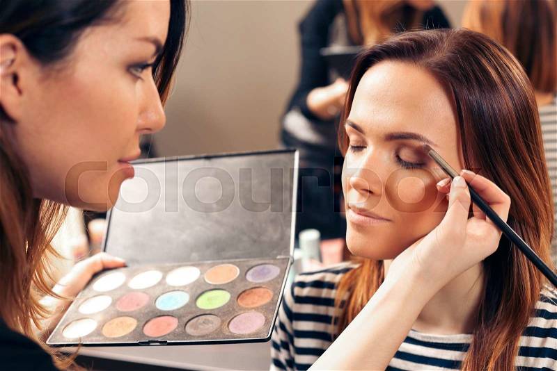 Make up eye shadow in beauty salon with palette of different colors, stock photo