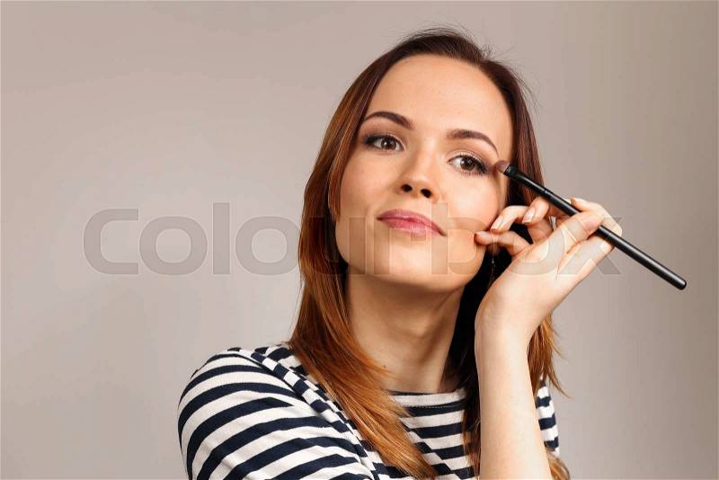 Applying eye makeup products on woman\'s face. Eyes Makeup. Eyes shadows. Eye shadow brush. Perfect face makeup process, stock photo