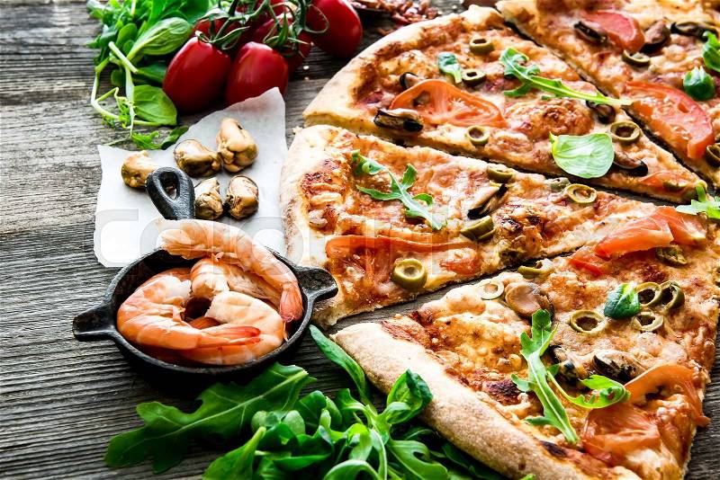Delicious pizza with seafood on wooden table, stock photo