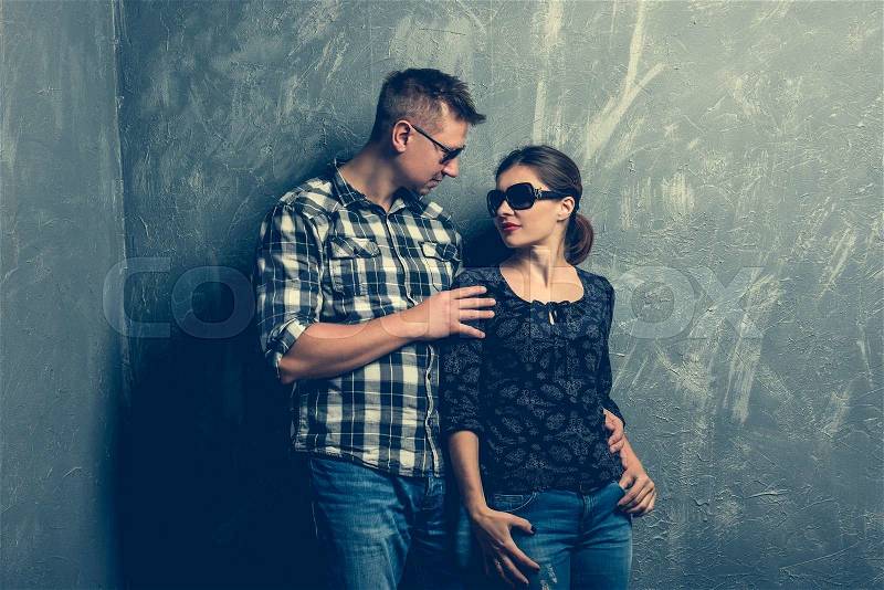 Portrait of couple facing each other on grey background, stock photo