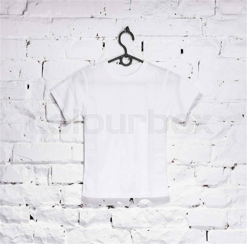 Texture of brick whitewashed wall with white t-shirt for kids on hanger, back, stock photo