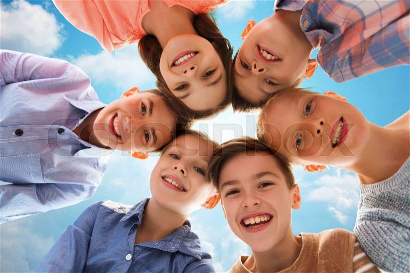 Childhood, fashion, summer, friendship and people concept - happy smiling children faces over blue sky and clouds background, stock photo