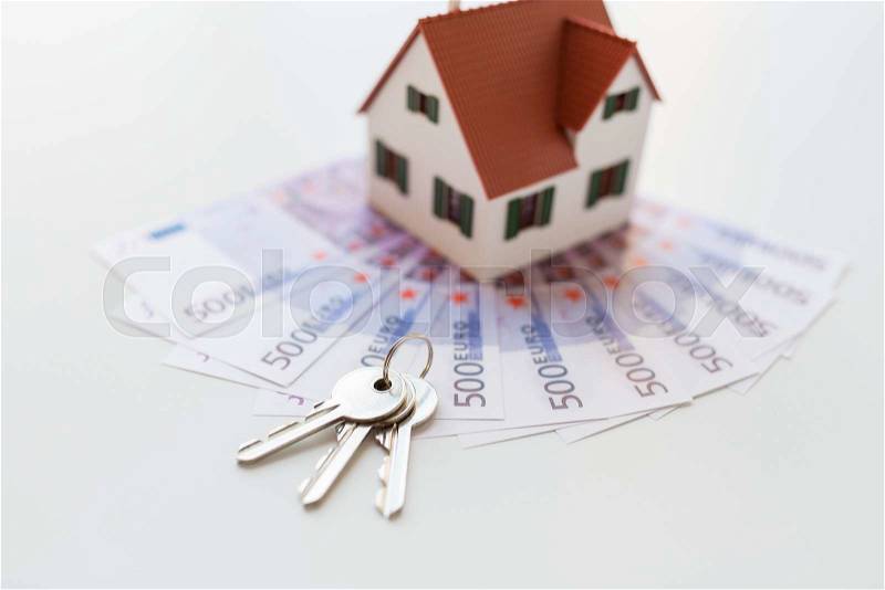 Mortgage, investment, real estate and property concept - close up of home model, money and house keys, stock photo