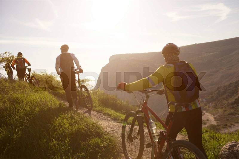 Group of people traveling through the countryside on mountain bikes, stock photo