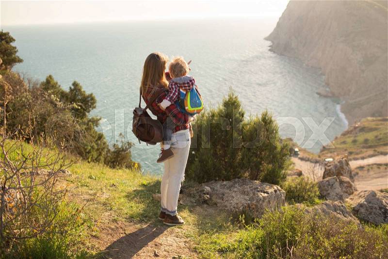 Beautiful family of mother and son walking near the sea, stock photo