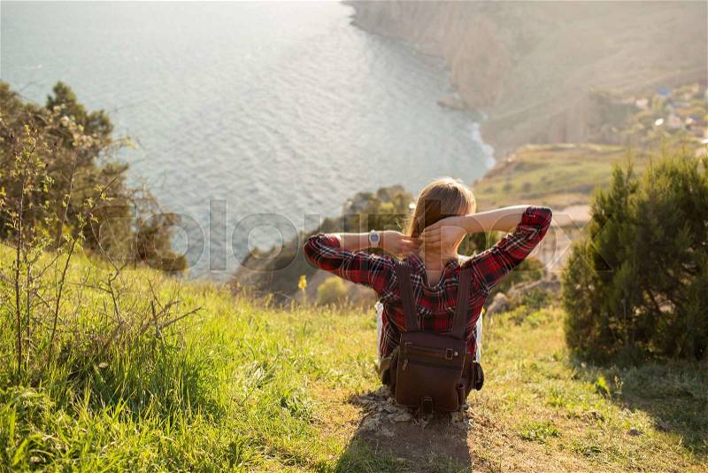 Young Woman resting near the sea at sunset. on background Travel Lifestyle and happiness concept, stock photo