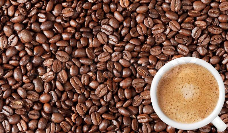 Close-up of coffee beans background and white coffee cup, stock photo