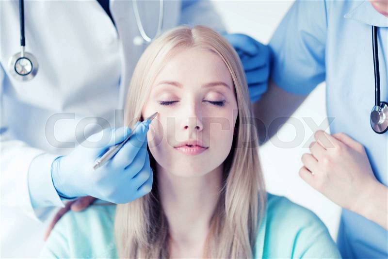 Healthcare, medical and plastic surgery concept - plastic surgeon and nurse with patient in hospital, stock photo