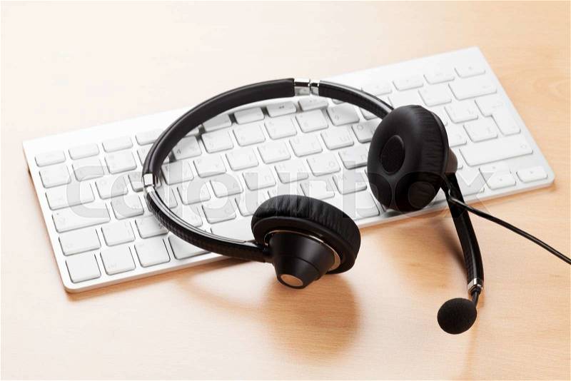 Office desk with headset and pc. Call center support table, stock photo