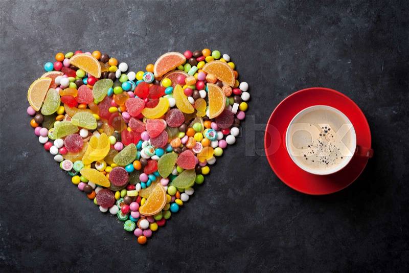 Colorful candies, jelly and marmalade heart and coffee cup on stone background. Top view, stock photo