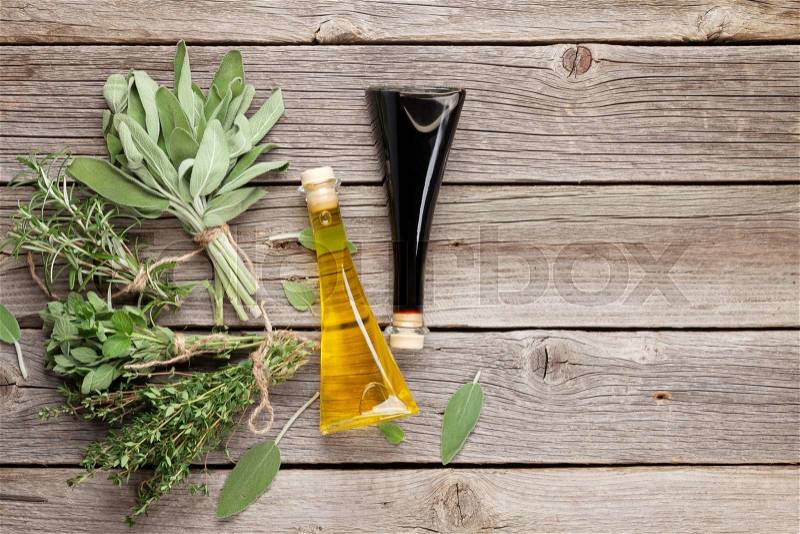 Fresh garden herbs and condiments on wooden table. Oregano, thyme, sage, rosemary. Top view with copy space, stock photo