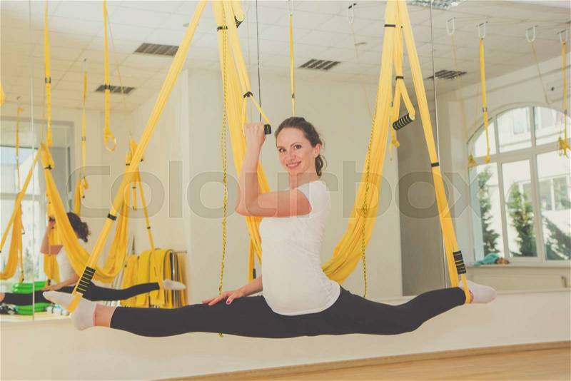 Girl doing splits and stretch legs on trx fitness straps, crossfit, stock photo